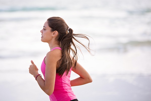 Solo female runner jogging on a beach